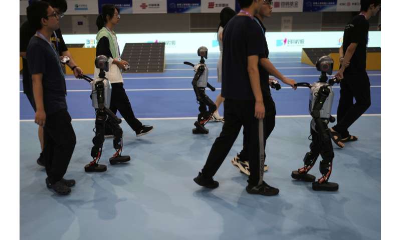 Les photos des jeux de robot humanoïde mondial de Pékin montrent comment une touche humaine est encore nécessaire
