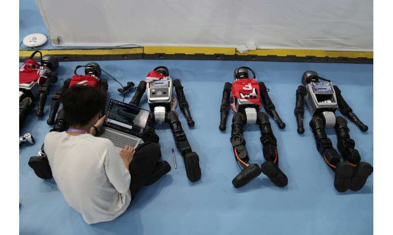 Les photos des jeux de robot humanoïde mondial de Pékin montrent comment une touche humaine est encore nécessaire